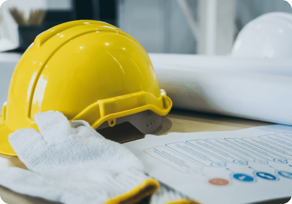 Planerstellung, ein Papier liegt auf dem Tisch neben einem Sicherheitsehelm